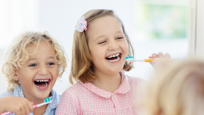 Bērni tīra zobus vannasistabā un skatās spogulī.