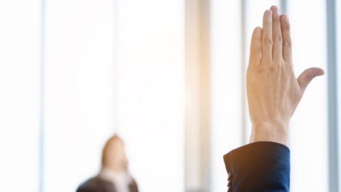 Vīrietis pacēlis roku, lai uzdotu jautājumu.