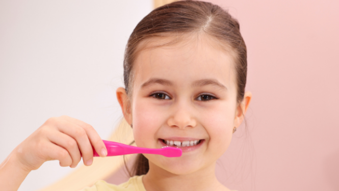 Meitene tīra zobus ar zobu birsti.