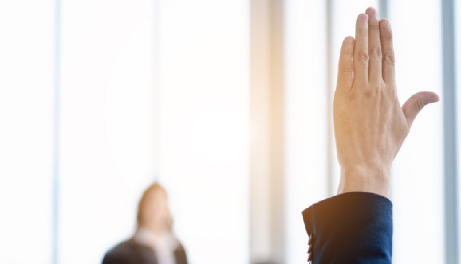 Vīrietis pacēlis roku, lai uzdotu jautājumu.