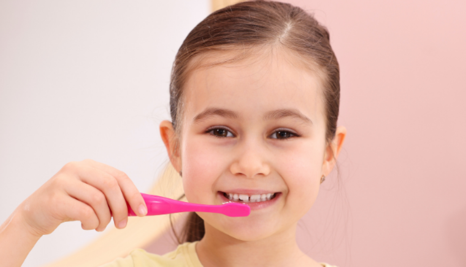 Meitene tīra zobus ar zobu birsti.