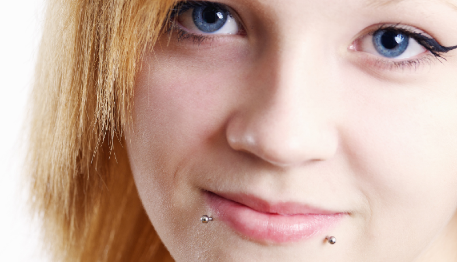 Jauna sieviete ar lūpu pīrsingiem.