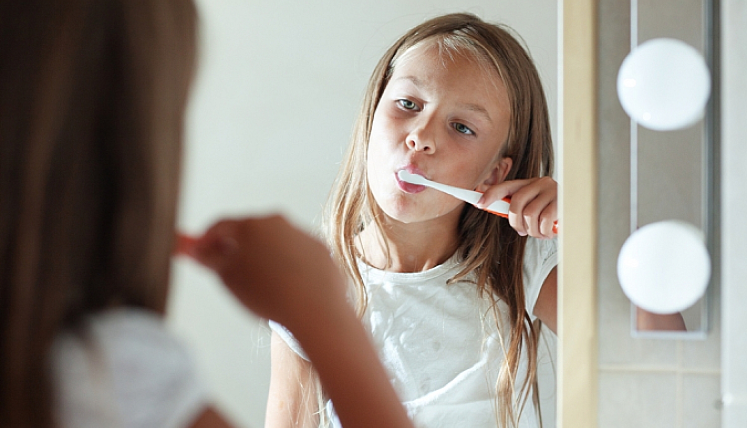 Meitene tīra zobus ar zobu birsti